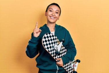 Kısa saçlı güzel İspanyol kadın elinde bir fikirle gülümsüyor ya da bir soru işareti yapıyor. 