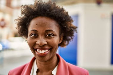 Güzel bir iş adamı Afro saçlı Amerikalı kadın şehirde mutlu ve kendinden emin bir şekilde gülümsüyor.