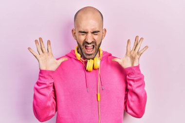 Spor kıyafetleri giyen ve kulaklık takan genç kel bir adam başarının çılgınlığını kutluyor kollarını kaldırmış ve gözlerini kapatmış heyecanlı çığlıklar atıyordu. Kazanan konsept 