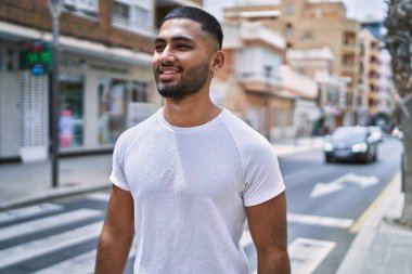 Orta Doğu 'lu genç adam gülümsüyor. Mutlu bir şekilde şehirde duruyor..