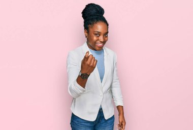 İş kıyafetleri giymiş genç Afro-Amerikalı kadın seni buraya davet ediyor. Mutlu ve mutlu bir şekilde karşılamaya davet ediyor. 