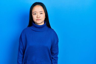 Sıradan kıyafetler giyen genç Çinli kız yüzünde ciddi bir ifadeyle rahatladı. Basit ve doğal bir şekilde kameraya bakıyorsun.. 