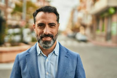 Orta yaşlı işadamı şehirde mutlu mesut dikilirken.