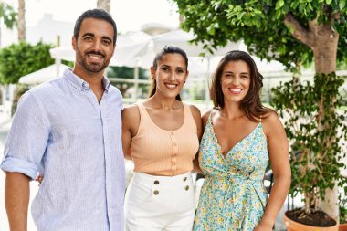 Üç İspanyol arkadaş şehirde mutlu bir şekilde gülüyor ve sarılıyorlar..