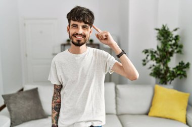 Evdeki oturma odasında sakallı, tek parmağıyla kafasını gösteren, harika bir fikir ya da düşünce sahibi, iyi bir hafızası olan İspanyol bir adam. 