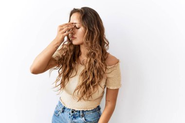 Arka plan yorgun burnu ve gözleri ovalayarak yorgunluk ve baş ağrısı hissederken, güzel İspanyol kadın tek başına ayakta duruyor. Stres ve hüsran kavramı. 