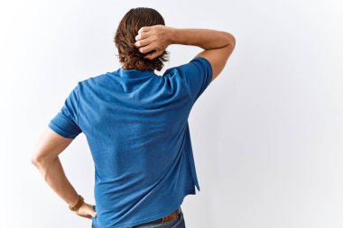 Yakışıklı orta yaşlı bir adam soyutlanmış arka planda yan yana dururken elleri başının üstünde şüpheyi düşünür. 