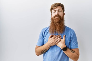 Uzun sakallı, soyutlanmış arka planda duran, elleri göğsünde, gözleri kapalı ve yüzünde minnet ifadesi olan beyaz bir adam. sağlık kavramı. 