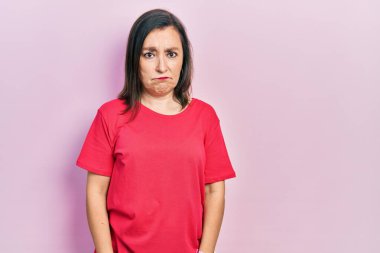 Orta yaşlı İspanyol kadın, günlük giysiler giyiyor, depresyonda ve endişe içinde, kızgın ve korkmuş bir şekilde ağlıyor. hüzünlü ifade. 