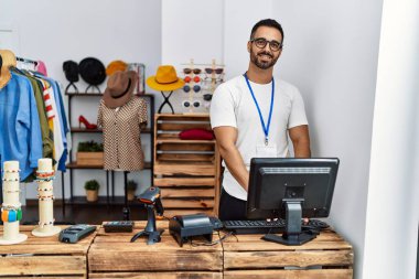 Genç İspanyol esnaf mağazada çalışırken gülümsüyor.