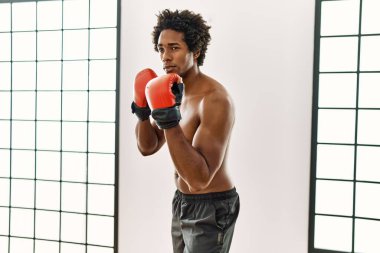 Genç Afrikalı Amerikalı adam spor salonunda boks yapıyor.