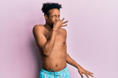 Sakallı, mayo giymiş genç Afro-Amerikan bir adam pis ve iğrenç bir koku alıyor. Dayanılmaz bir koku. Parmakları burnunda nefesini tutuyor. Kötü kokuyor. 