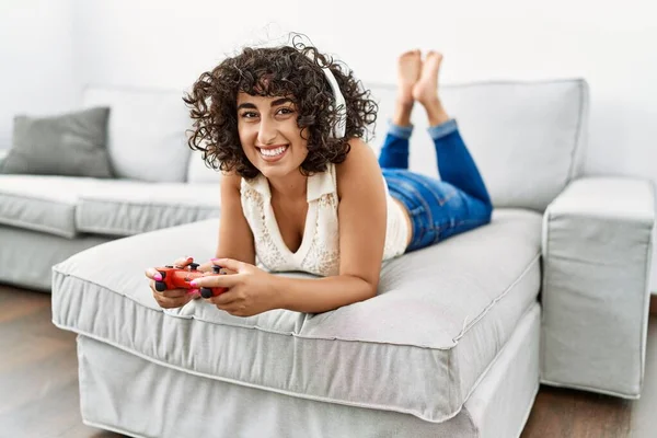 年轻的中东女人笑着自信地在家里玩电子游戏 — 图库照片