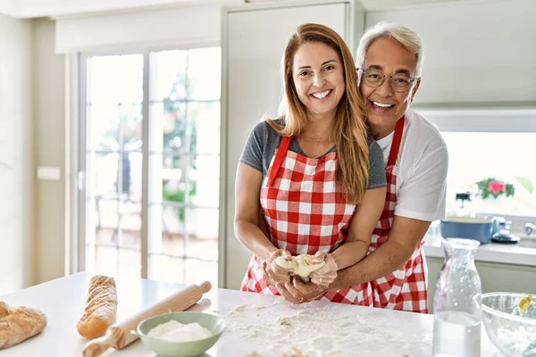 Casal Hispânico Meia Idade Sorrindo Feliz Abraçando Pão Cozinha Cozinha — Fotografia de Stock