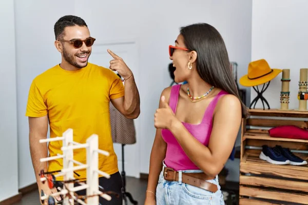 Joven Pareja Latina Sonriendo Feliz Eligiendo Gafas Sol Tienda Ropa —  Fotos de Stock