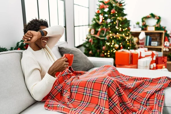 Jovem Afro Americano Sentado Sofá Bebendo Café Pela Árvore Natal — Fotografia de Stock