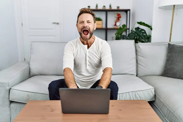 Középkorú Férfi Laptopot Használ Otthon Dühösen Őrülten Sikoltozva Frusztráltan Dühösen — Stock Fotó
