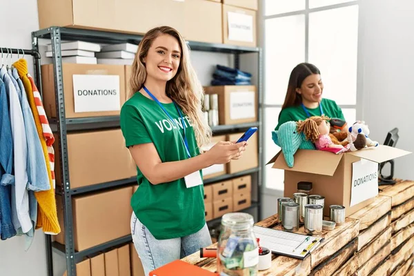 Duas Jovens Voluntárias Sorrindo Felizes Trabalhando Centro Caridade Menina Sorrindo — Fotografia de Stock