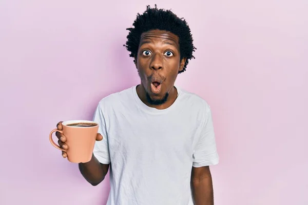 Junge Afrikanisch Amerikanische Mann Mit Tasse Kaffee Verängstigt Und Erstaunt — Stockfoto