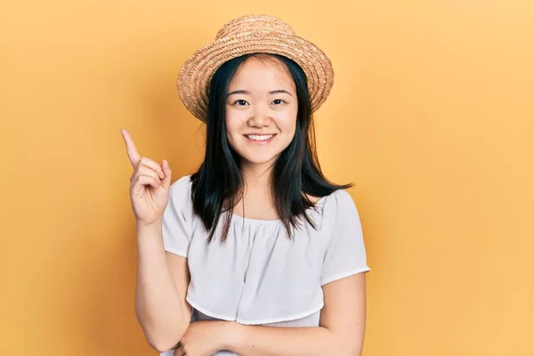 戴着夏帽的中国小女孩高兴地微笑着 手指手画脚地朝旁边走去 — 图库照片