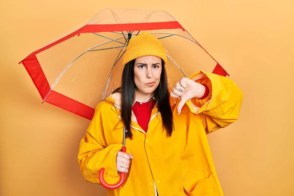 Junge Hispanische Frau Gelbem Regenmantel Mit Regenschirm Und Wütendem Gesicht — Stockfoto
