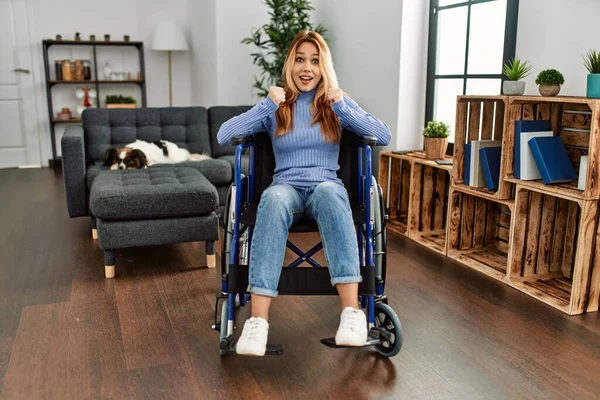 Jovem Bela Mulher Sentada Cadeira Rodas Casa Comemorando Surpreso Surpreso — Fotografia de Stock