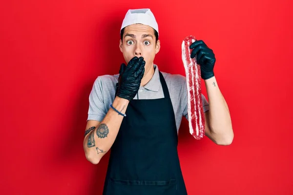 Young Hispanic Man Wearing Cook Apron Holding Meat Covering Mouth — Stock Photo, Image