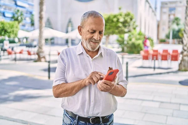 Senior Férfi Mosolygós Magabiztos Segítségével Smartphone Utcán — Stock Fotó