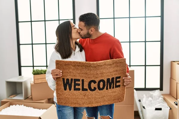 Young Latin Couple Kissing Holding Welcome Doormat New Home — Stock Photo, Image