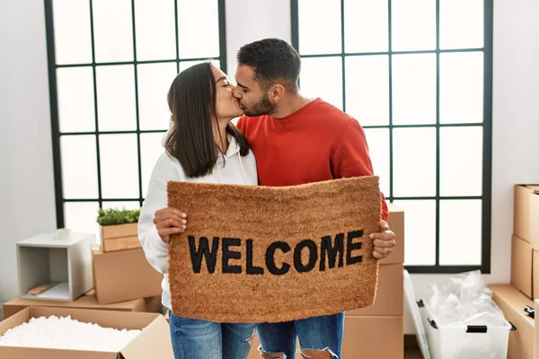 Jovem Casal Latino Beijando Segurando Capacho Boas Vindas Nova Casa — Fotografia de Stock