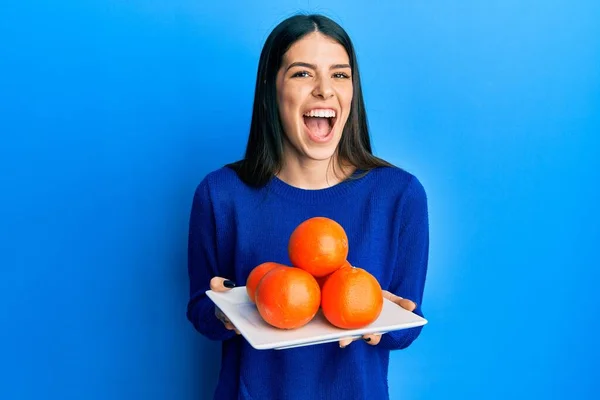 Junge Hispanische Frau Hält Teller Mit Frischen Orangen Lächelt Und — Stockfoto