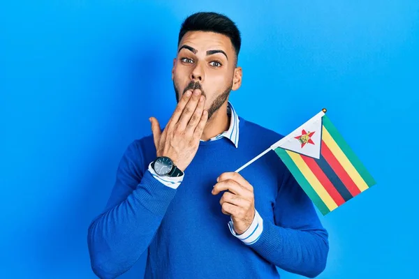 Junger Hispanischer Mann Mit Bart Und Zimbabwe Fahne Der Mund — Stockfoto