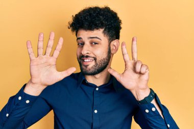Sakallı, sıradan gömlekli genç bir Arap sekiz numarayı gösterip işaret ederken kendinden emin ve mutlu gülümsüyor.. 