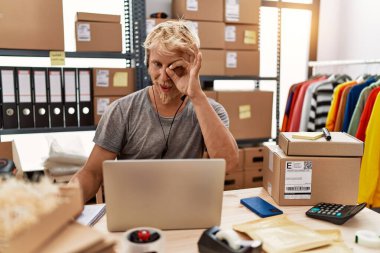 Operatör kulaklığı takan genç sarışın adam internet dükkanında gülümsüyor. 