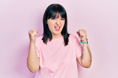 Öfkeli ve kızgın giyinmiş genç İspanyol kadın öfkeyle bağırırken kızgın ve öfkeli yumruklar sallıyor. öfke ve agresif konsept. 