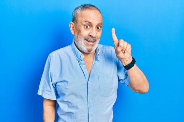 Sakallı, sıradan mavi gömlekli yakışıklı, başarılı bir fikir olduğunu gösteren bir adam. Heyecanlı ve mutlu. Bir numara.. 