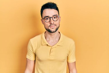 Günlük kıyafetler ve gözlük takan genç İspanyol adam yüzünde ciddi bir ifadeyle rahatladı. Basit ve doğal bir şekilde kameraya bakıyorsun.. 