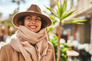 Şık giyinen genç İspanyol kadın şehirde dikiliyor..