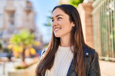 Sokakta kendinden emin gülümseyen genç bir kadın