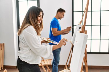 Sanat okulunda mutlu resim yapan iki öğrenci.