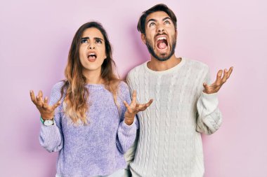 Genç İspanyol çift gündelik kıyafetler giyip deli gibi bağırıyor ve agresif bir ifade ve kollarla bağırıyor. hüsran kavramı. 