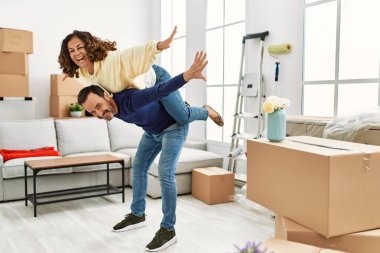 Yeni evinde kadını sırtında taşıyan bir adam.