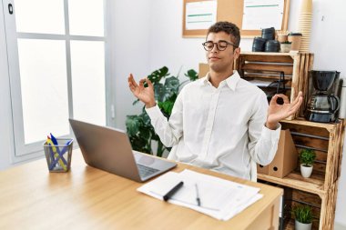 İş yerinde dizüstü bilgisayarla çalışan genç bir İspanyol.