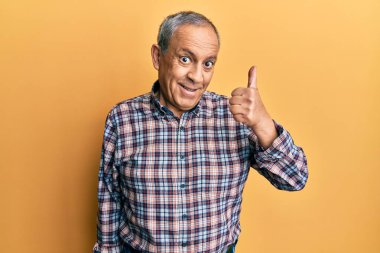 Gri saçlı, sıradan tişörtlü, yakışıklı bir son sınıf öğrencisiydi. Elleriyle mutlu bir jest yapıyordu. Kameraya bakıp başarıyı gösteren ifade. 