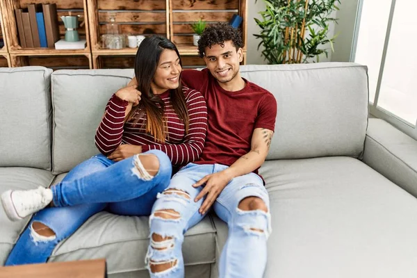 Jovem Casal Latino Sorrindo Feliz Abraçando Sentado Sofá Casa — Fotografia de Stock
