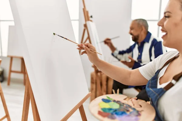 若い芸術家の女性とアートスタジオの教室でシニア画家の男性ブラシと油絵でキャンバス上の絵画 — ストック写真