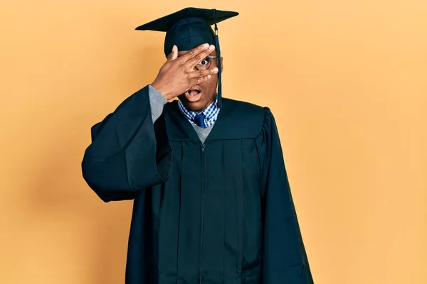 Junger Afrikanisch Amerikanischer Mann Mit Abschlussmütze Und Zeremoniengewand Der Schockiert — Stockfoto