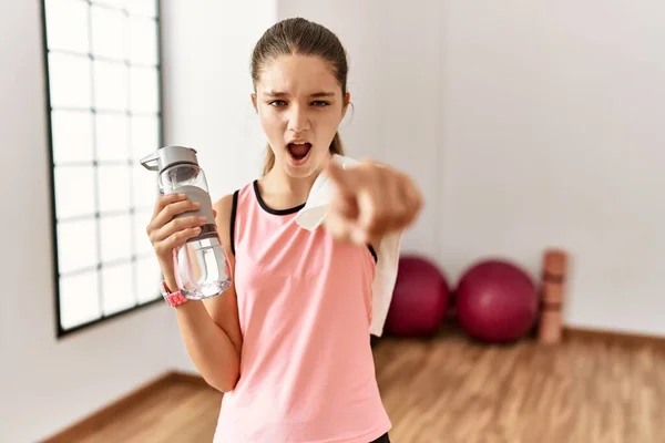 Joven Morena Adolescente Con Ropa Deportiva Sosteniendo Botella Agua Señalando —  Fotos de Stock