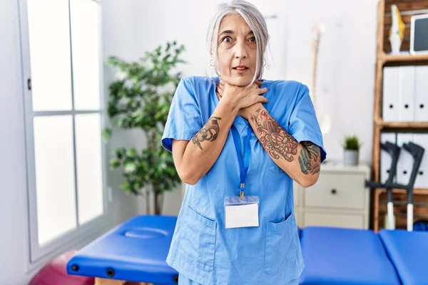 Medelålders Gråhårig Kvinna Bär Sjukgymnast Uniform Läkarmottagningen Skriker Och Kvävs — Stockfoto