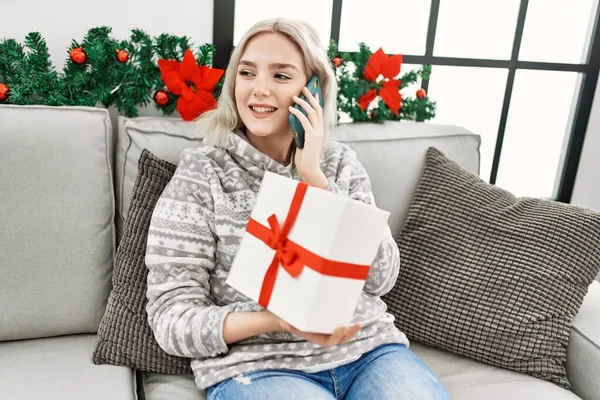 Молода Біла Дівчина Розмовляє Смартфону Тримаючи Різдвяний Подарунок Вдома — стокове фото